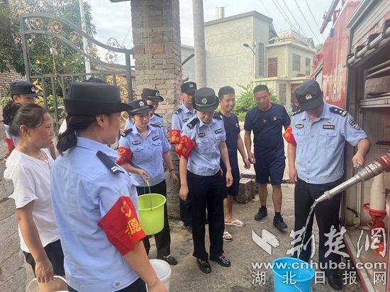 民輔警跟隨消防水車作業(yè)，通過肩挑手提的方式將清水送入行動不便的老年、殘障村民的家中（通訊員 李麗君 攝） (3).jpg.jpg